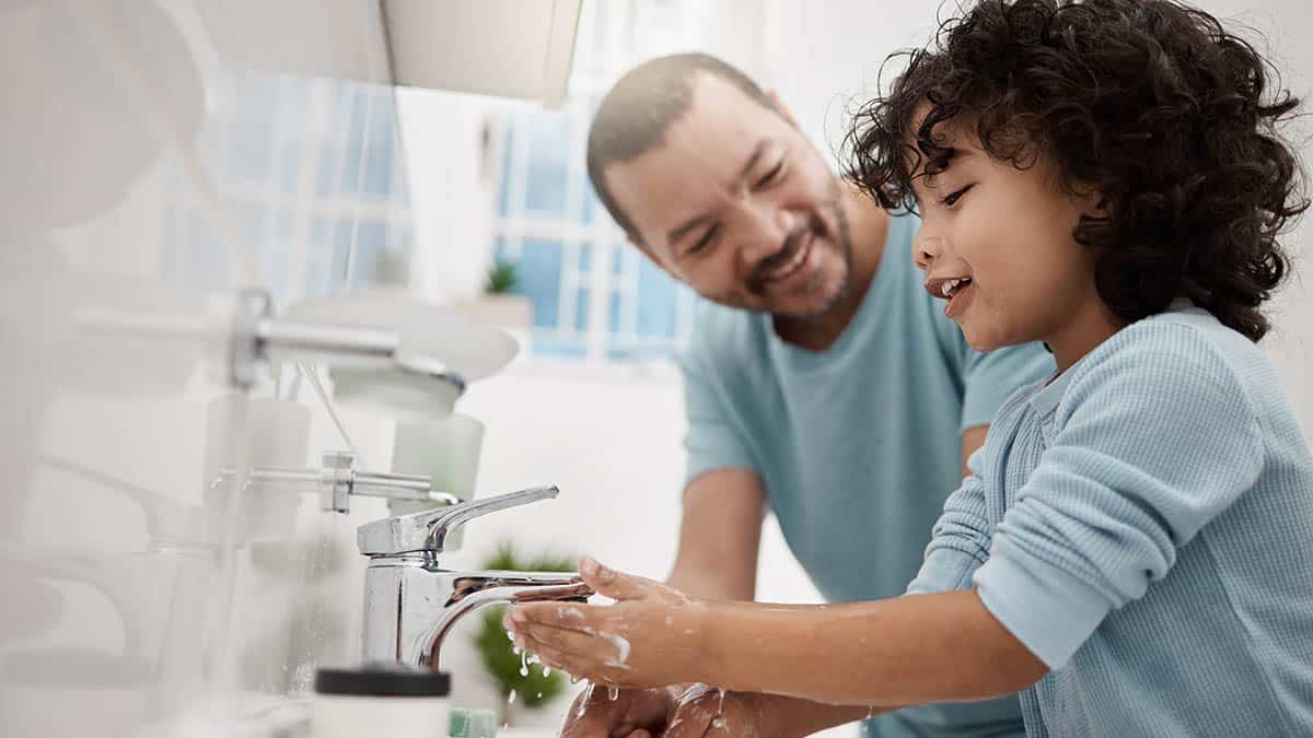 Shot of a father helping his son wash his hands and face at a tap in a bathroom at home blog WaterHeaters 1200x675 1